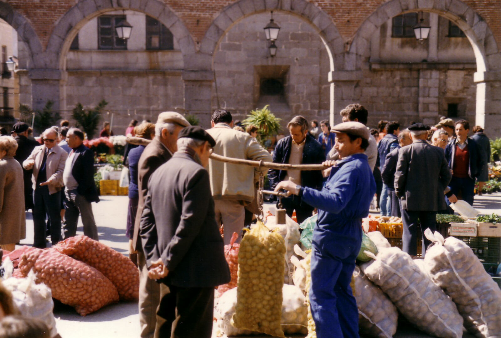 Weighing potoatoes in the market in Plaza de la Victoria, Avila, Spain