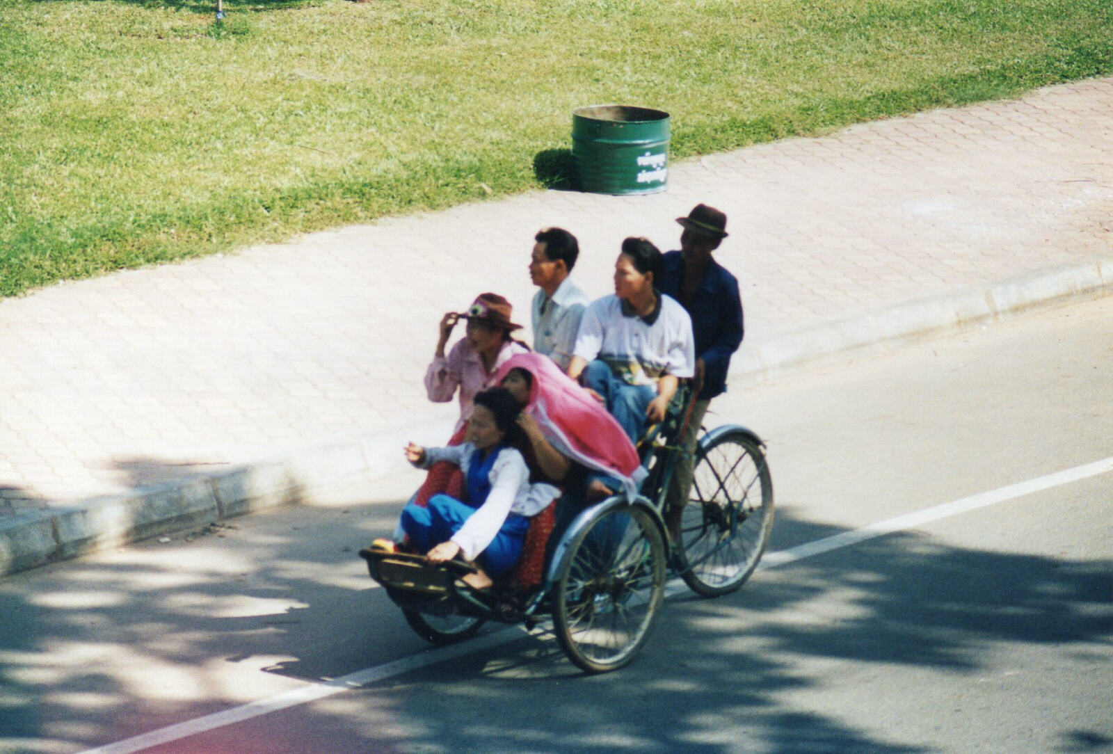 Five passengers on a cyclo outside Hotel California, Phnom Penh, Cambodia