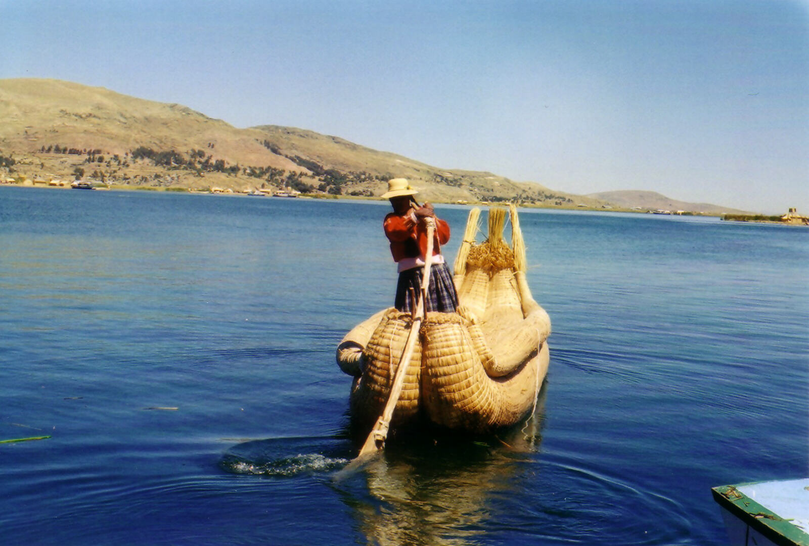 A Uros lady in a reed boat on Lake Titicaca, Peru