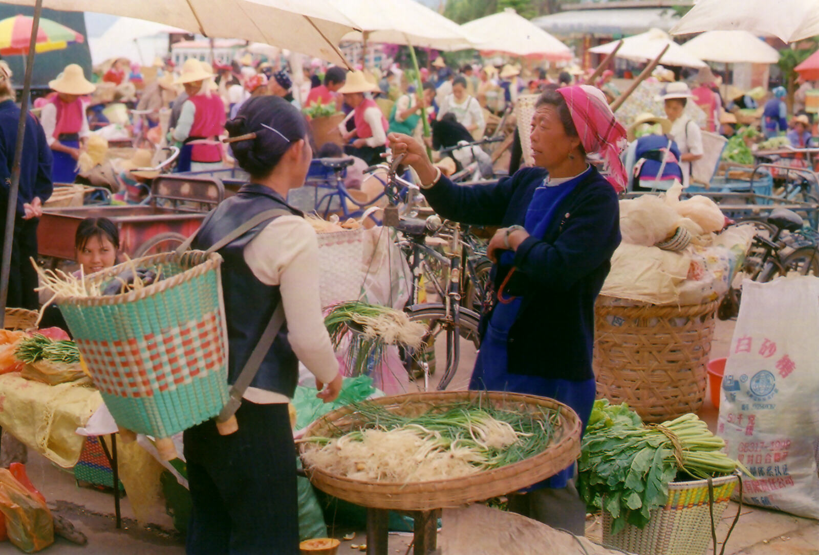 Weighing out out vegetables at Wa'se market near lake Erhai, Dali, China