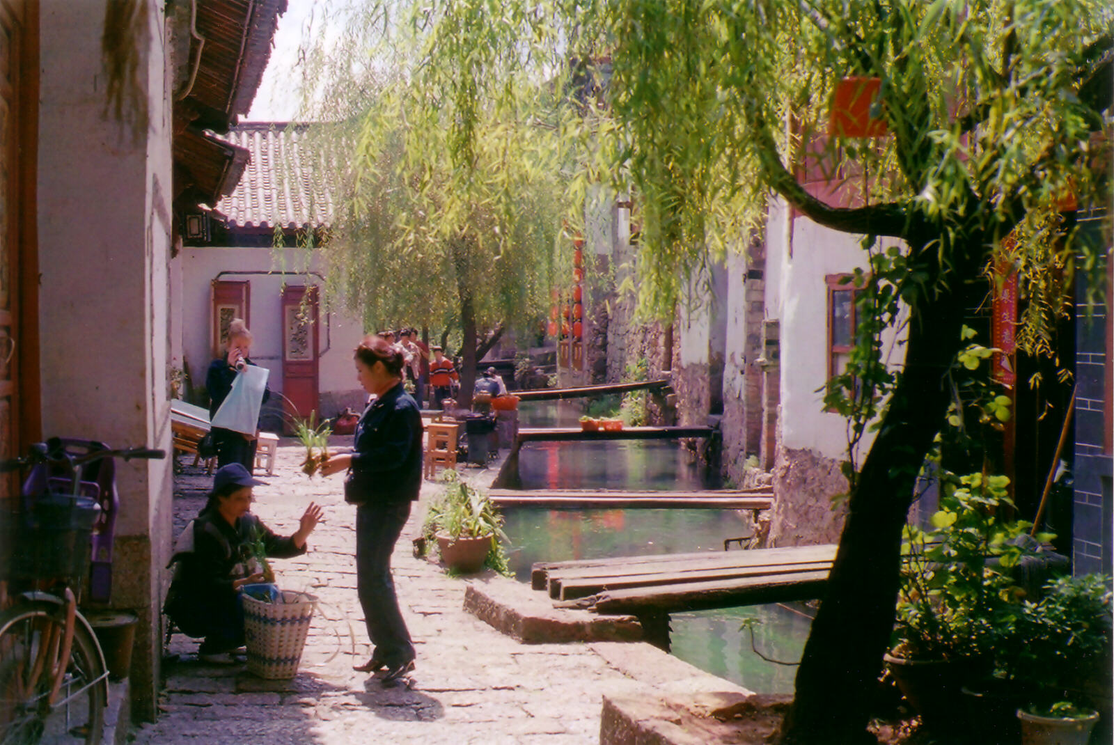 Cobbled street by a sparkling river in Lijiang, China