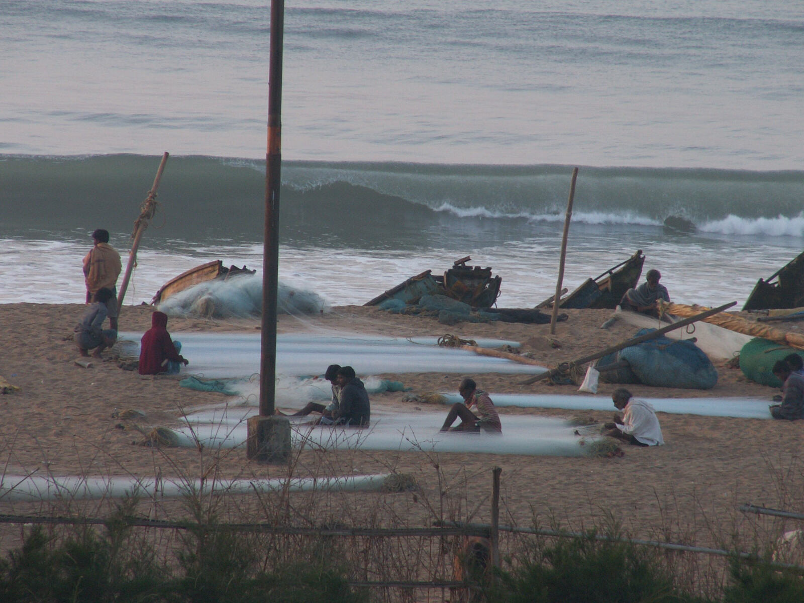 Fishermen mending nets on Puri beach, India