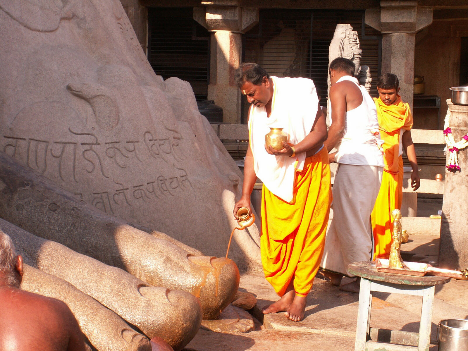 Annointing Gometaswara statue's feet at Sravanabelagola Jain temple, India