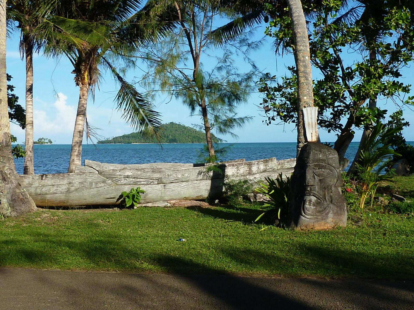 Wooden canoe and statue on the seafront on Wallis island