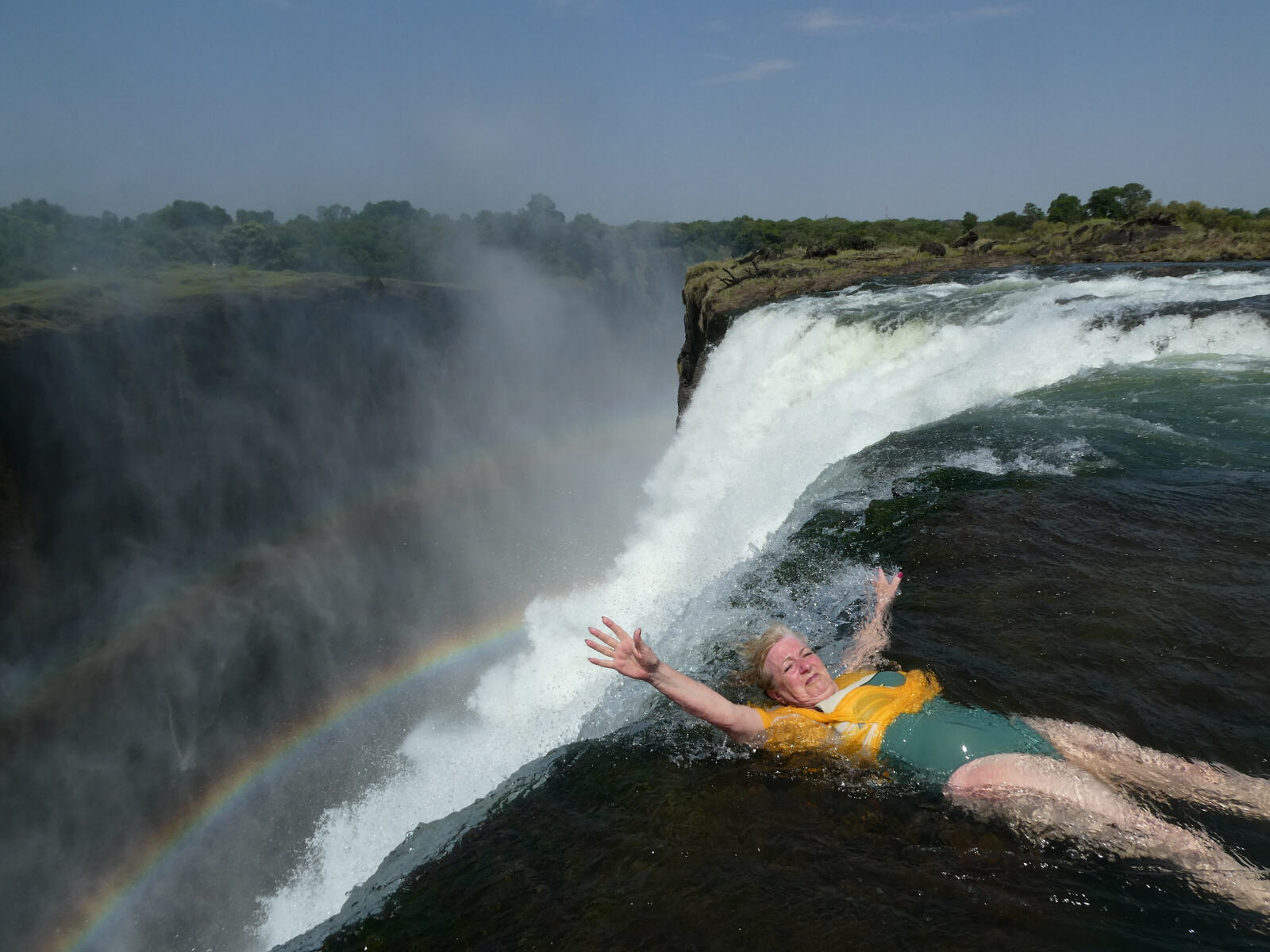 Sheila on the edge of Victoria Falls at Devils Pool